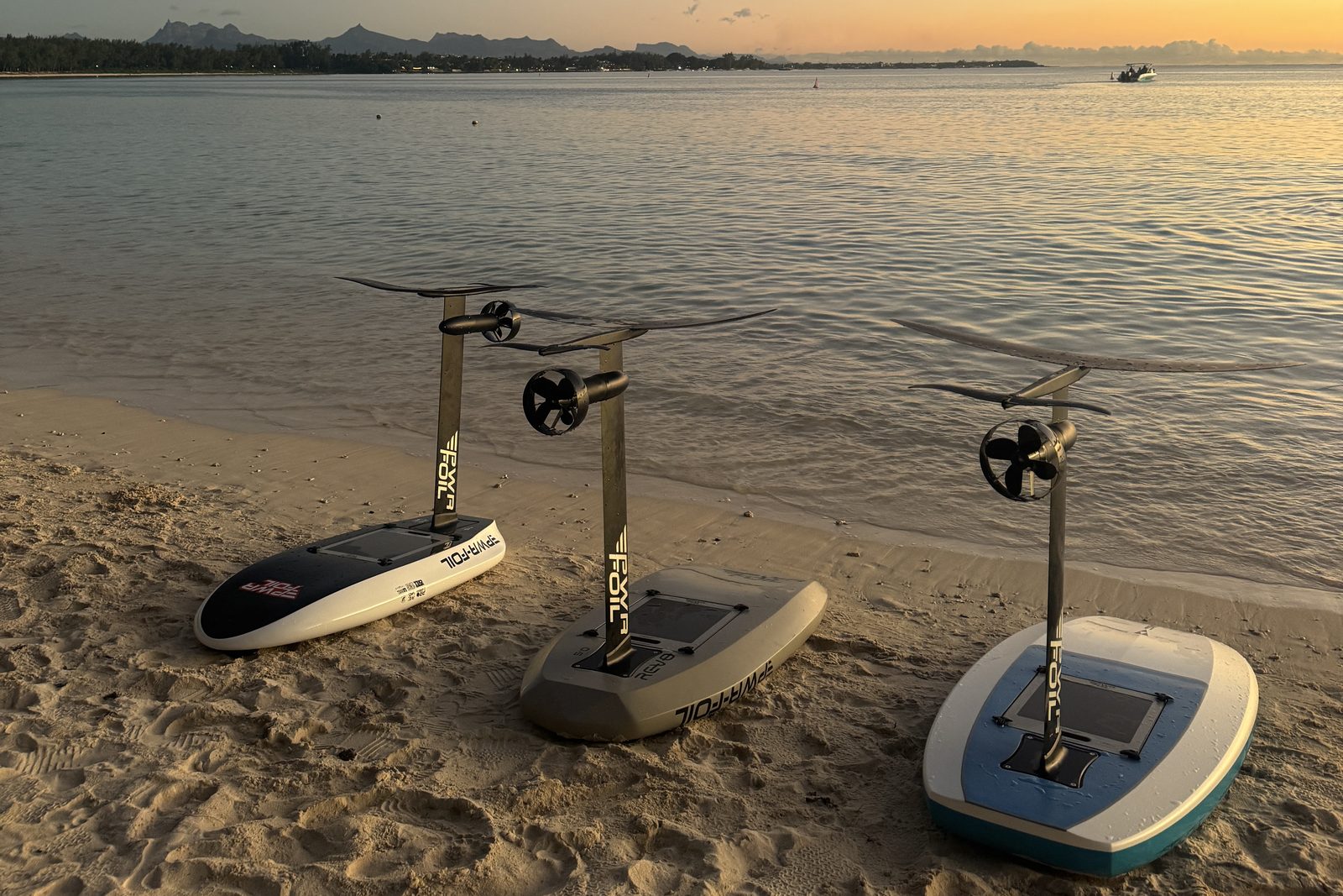 Trois planches eFoil PWRFOIL posées sur le sable au coucher du soleil, lagon du Nord de l'île Maurice