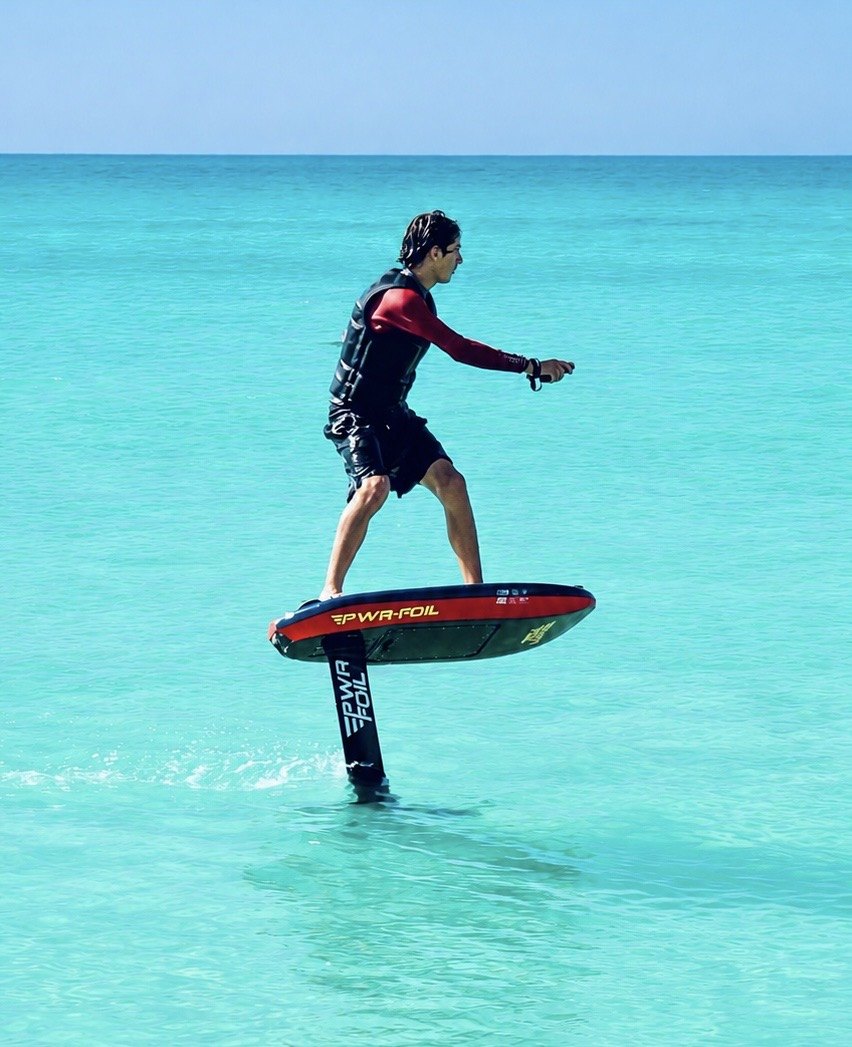 Rider en vol sur un eFoil PWRFOIL lors d'un essai privé dans le lagon de l'île Maurice